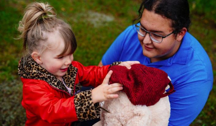 Interpreter showing Mr. Bear to a young girl 